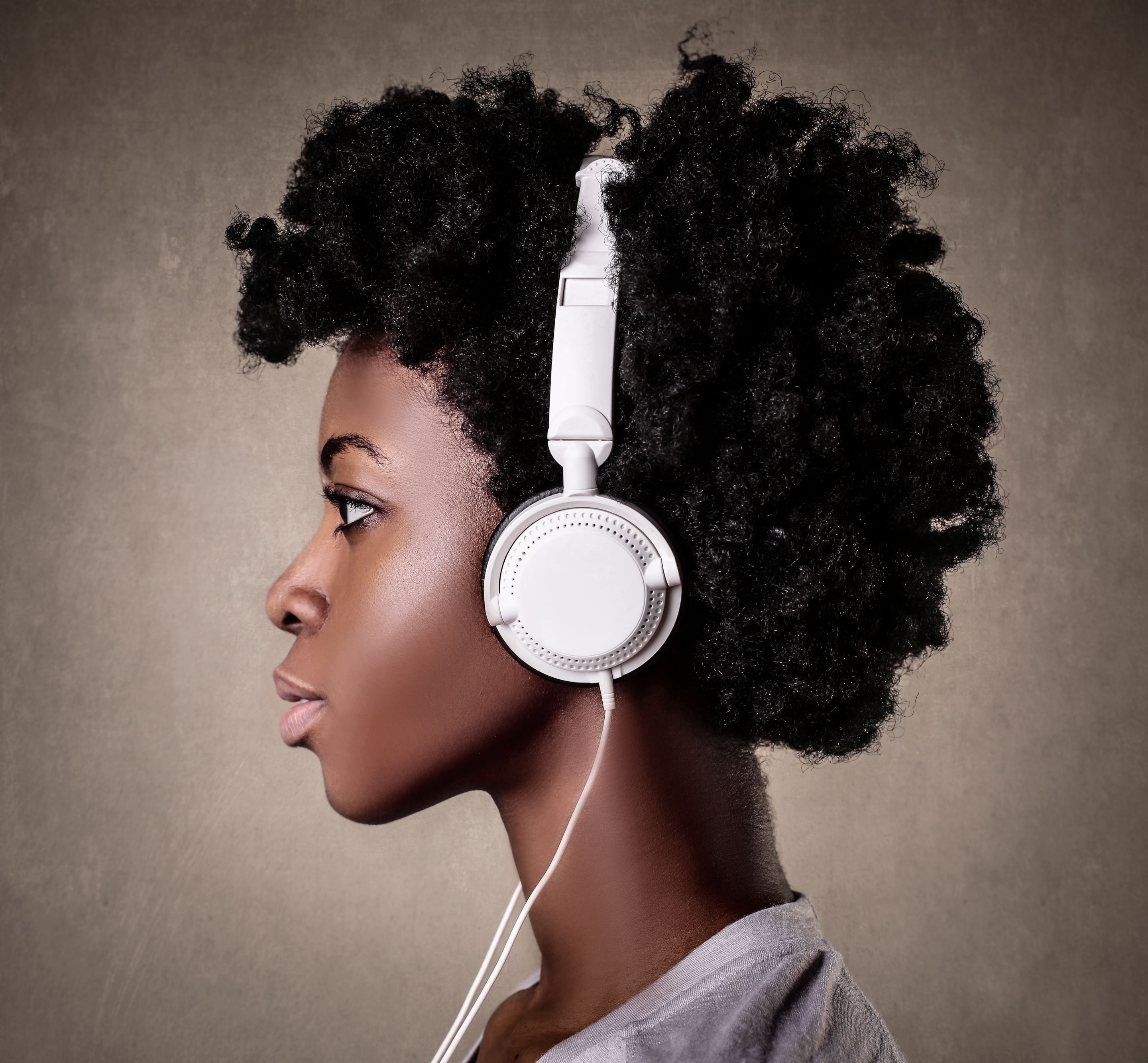 portrait-young-black-female-with-curly-hair-listening-music-with-white-headphone.jpg