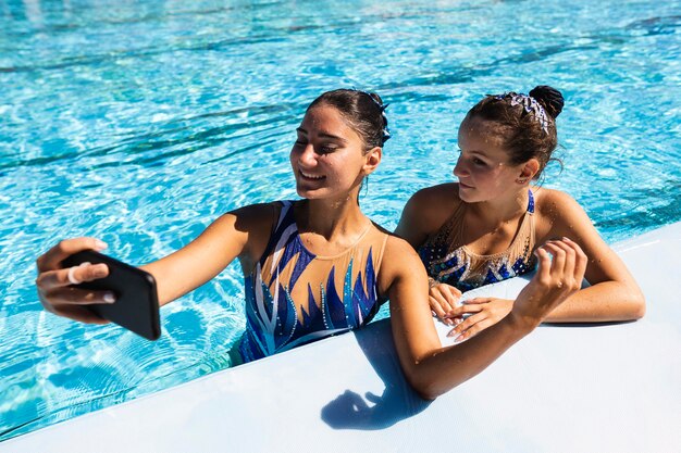 smiley-young-girl-taking-selfie-pool_23-2148699990.jpg