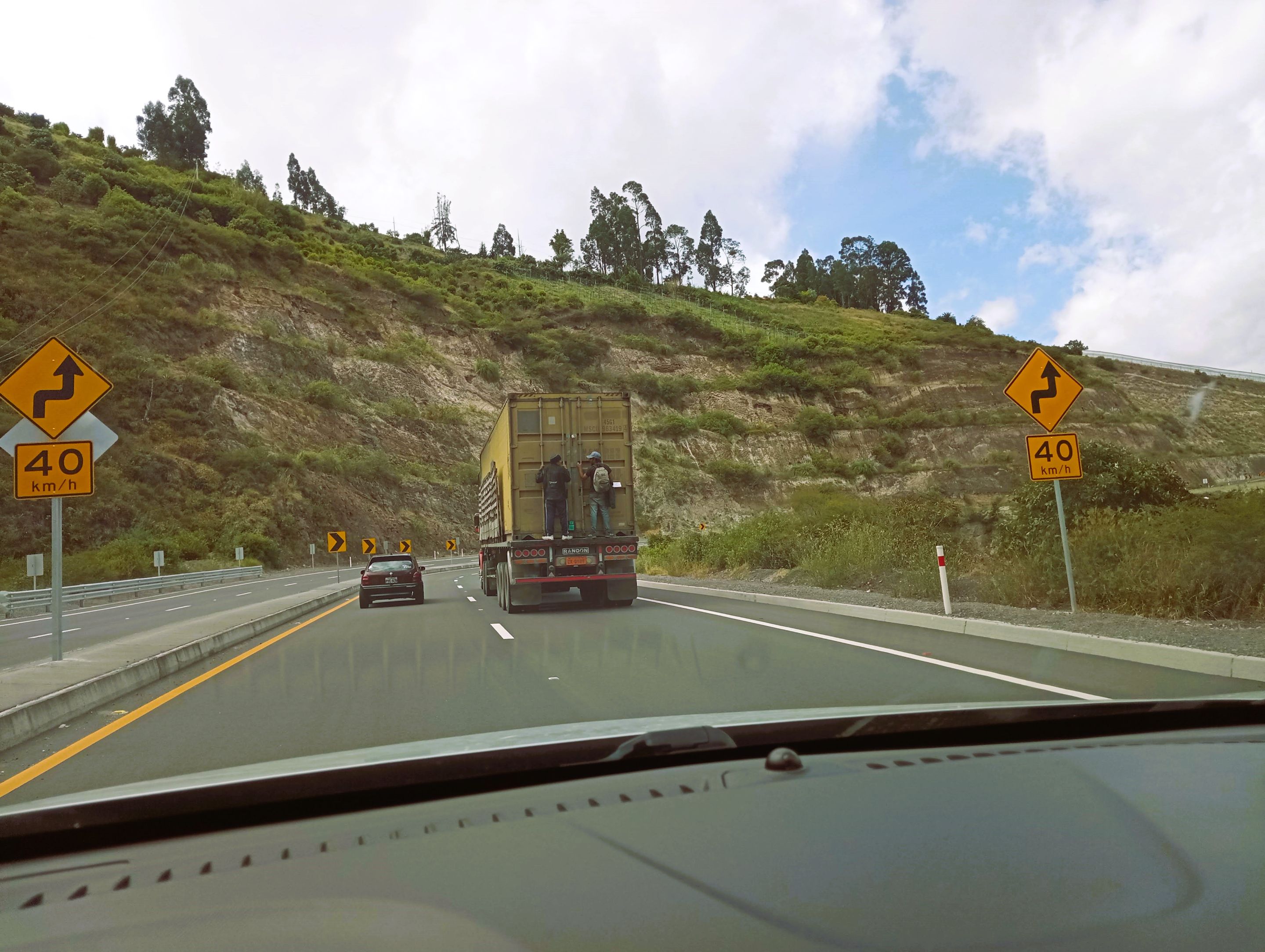 On the Panamerican Highway. Many people from Venezuela don't have the means to pay for tickets, even as cheap as they are in Ecuador, so they hitchhike - or cling on the back of containers for hours.