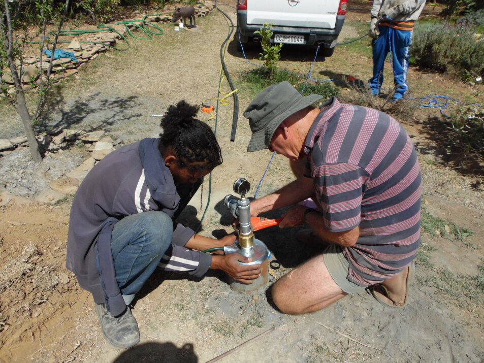The Husband and my gardener (still working for me) installing the submersible borehole pump