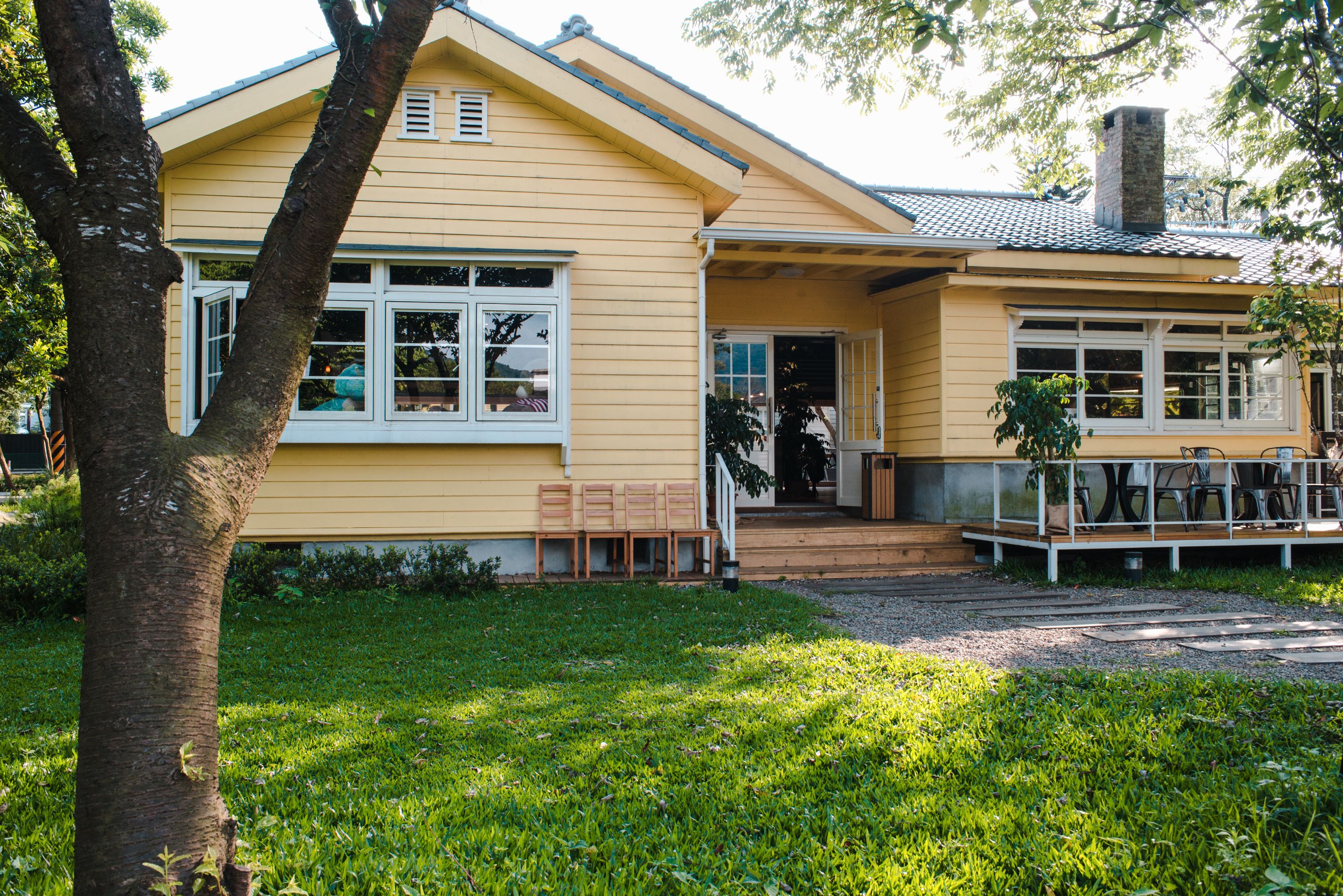 charming-yellow-house-with-wooden-windows-green-grassy-garden.jpg