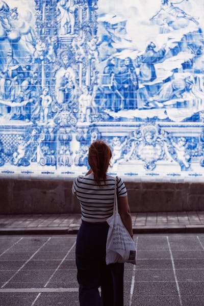 free-photo-of-a-woman-walking-down-a-sidewalk-with-a-blue-and-white-tile-mural.jpeg