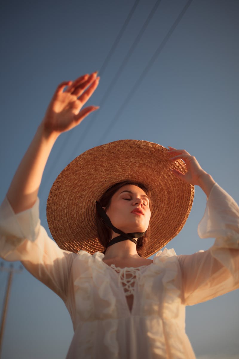 free-photo-of-woman-wearing-a-straw-hat-raising-her-hand.jpeg
