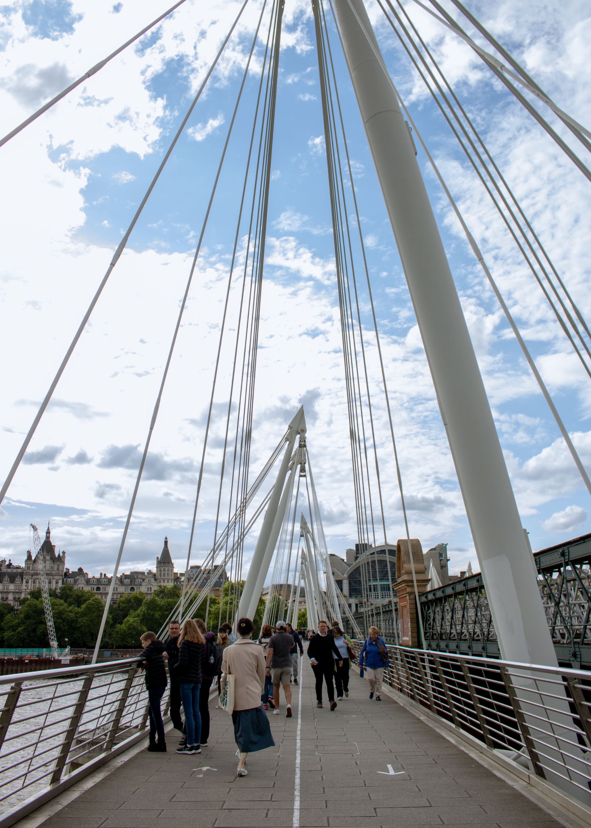 People crossing bridge by the London Eye and Big Ben.jpg