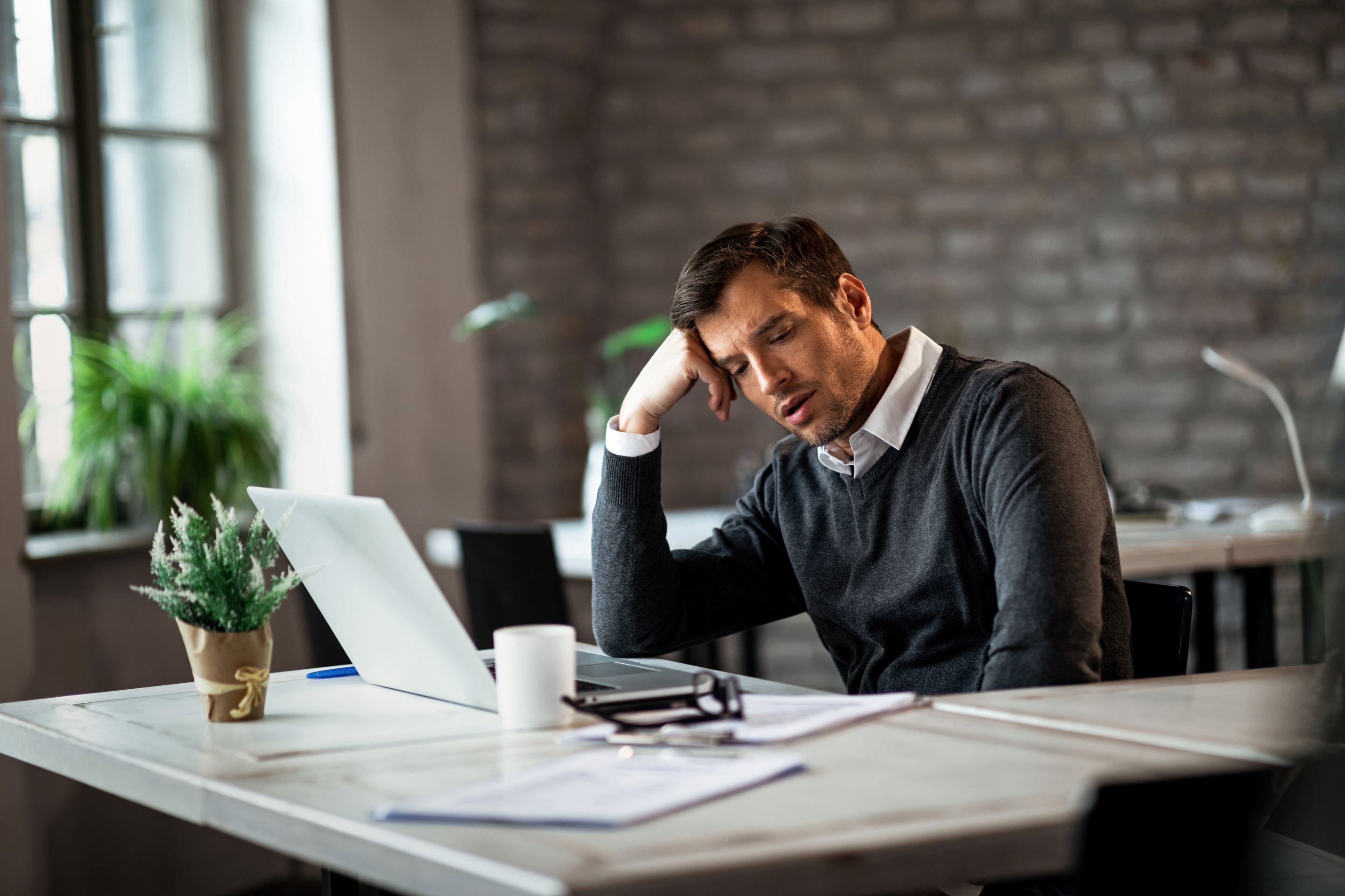hombre-negocios-exceso-trabajo-sentado-su-escritorio-pensando-algo-oficina.jpg
