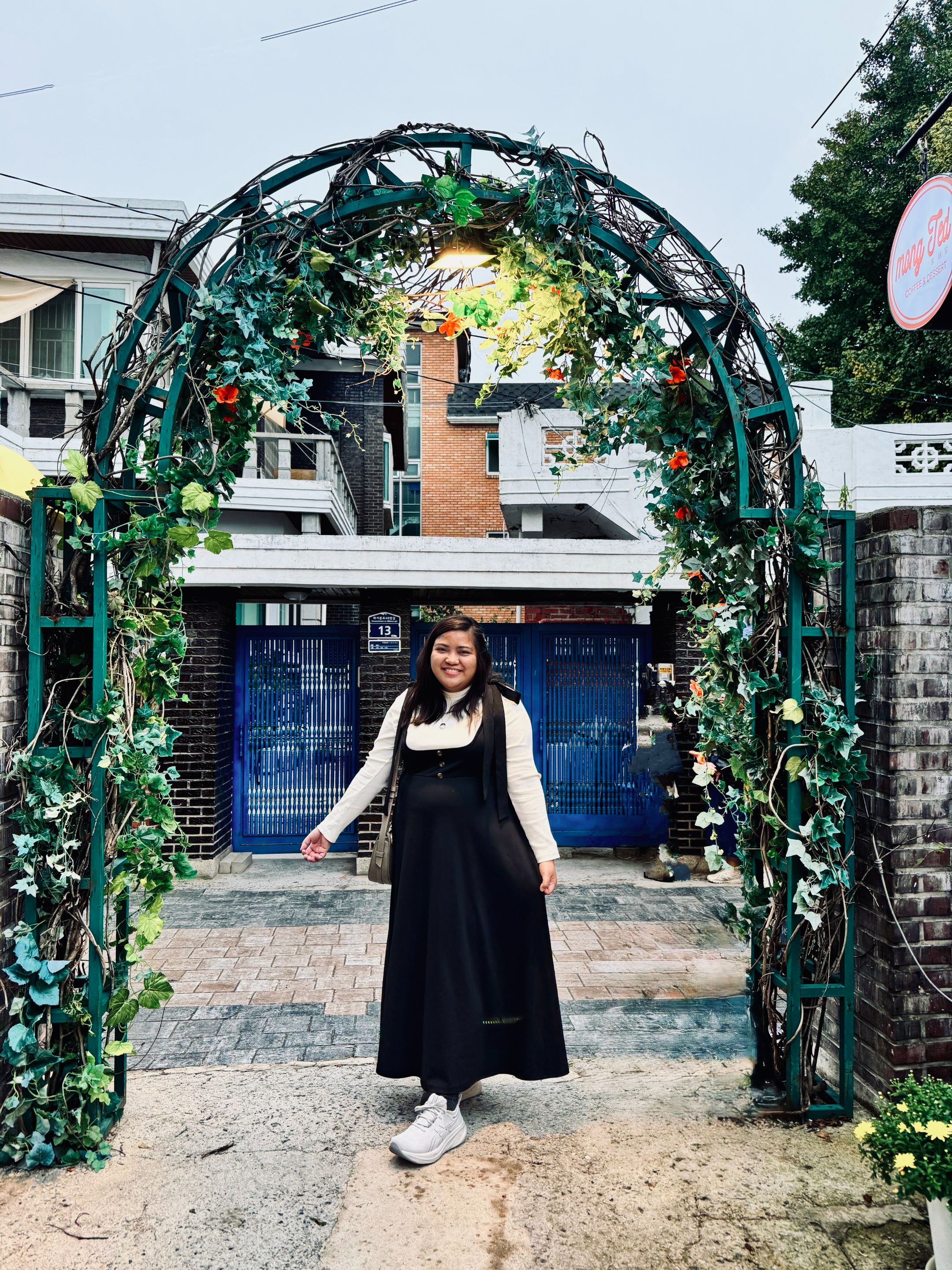 a cute arc outside Sol's house with Sun-jae's house in the background